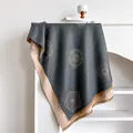 Dettaglio del motivo a camelia su una spessa sciarpa reversibile in finto cashmere con frange - Grigio