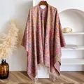 Close-up of bohemian paisley knit shawl with soft colorful fringe and ethnic patterns - Pink