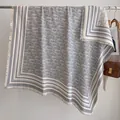 Detail eines eleganten grau-beigen Jacquard-Schals mit Buchstabenmuster und Fransen - Fj048-grau / 130x130cm