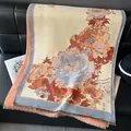 Elegante scialle beige effetto cashmere con motivi floreali di pivoine arancioni e frange - 185x65cm / Arancione