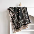 Detail eines Kaschmirschals mit Paisley-Muster und Fransen im Bücherregal - Schwarz