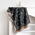 Detail of paisley pattern and soft fringe on the double-sided black and beige scarf - 185x65cm / Black