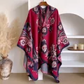 Detail van de retro bloemenpatronen en fijne stiksels op de dikke rode poncho - 130x152cm / Rozerood