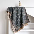 Thick paisley print scarf with fringe edges draped elegantly over a minimal white shelf - 185x65cm / Slate Gray