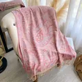 Close-up of pink paisley floral jacquard scarf with decorative fringe on a white sofa - 195x70cm / Peach