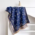 Blue and beige paisley cashmere scarf with fringes shown folded on a shelf - 185x65cm / Dark Blue