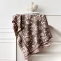 Detailed view of floral jacquard patterns and short tassels on a thick cashmere-like shawl - 185x65cm / Gray