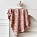 Detailed view of floral jacquard texture and fringes on pink cashmere-like shawl - 185x65cm / Pink