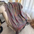 Detailed texture of bohemian paisley shawl with fringe on an armchair - Deep purple