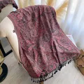 Detail of bohemian paisley shawl with fringe trim on a chair in soft sunlight - Dark Red