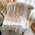 Bufanda crema tacto cachemir con bordado dorado y flecos blancos sobre una silla - 200x70cm / Blanco