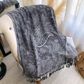Dunkelgrauer Paisley-Jacquardschal mit eleganten langen Fransen über einem Stuhl - Dunkelgrau