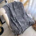 Ethnic paisley tassel shawl in black and gray colorway draped on a stylish sofa - Dark Gray