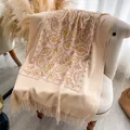 Chale de cachemira beige con bordados florales dorados y flecos sobre silla - 200x70cm / Color Piel