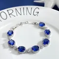 Close-up of sparkling oval blue gemstone bracelet with micro-pave crystals on white plate - Sapphire Blue