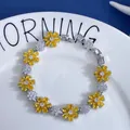 Detailed shot of floral zircon bracelet with yellow flowers on a white plate - Yellow