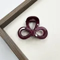 Dettaglio della molletta per capelli a fiocco rosso bordeaux lucido con molla in metallo - Stile Fiocco (Stile Due)