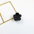 Elegant matte black flower hair claw clip with five-petal design on white surface - Black