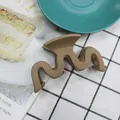 Matte brown wave-shaped hair claw clip for elegant hairstyles on white plaid fabric - Light Coffee