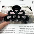 Molla per capelli a fiore nero opaco con design traforato e finitura satinata - Nero