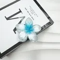 Dettaglio macro di un fermaglio per capelli a fiore di frangipane sfumato blu e bianco su sfondo - 8cm / Blu Olografico