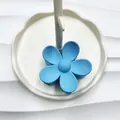 Pinza per capelli a fiore blu opaco con design minimalista a cinque petali su vassoio - Celeste