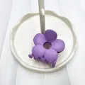 Pinza per capelli a fiore cavo viola opaco su un vassoio bianco minimalista - Viola