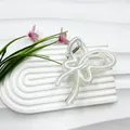 Transparente Schmetterling-Haarklammer mit weißem Seildetail auf weißer Steinplatte - Hellgelb und Weiß