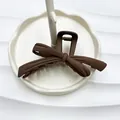 Matte dark brown bow-shaped hair claw clip for thick hair displayed on ceramic tray - Rubber Paint Dark Coffee