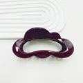 Glossy burgundy hair claw clip with cloud-like wave design on white textured background - Ankora Red
