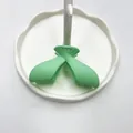 Pinza per capelli a fiocco verde menta opaco su un piatto bianco ondulato - Verde