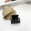 Glossy black plastic small hair claw clip for elegant women styling on minimalist background - Black