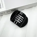 Polished black flat round hair clip with horizontal stripes on a white background - Bright Black
