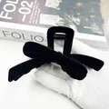 Elegant black flocked bow hair claw clip for women held against a fashion magazine - Bow Style (Style 2) / Black