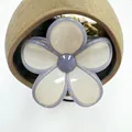 Close-up of a jelly-textured frangipani hair claw clip with creamy white flower petals - Beige with Gray Trim