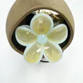 Detailed view of the yellow flower hair claw clip with blue edges on a ceramic base - Yellow with Blue Trim