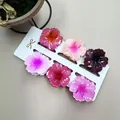 Detail von bunten Plumeria-Blüten-Haarklammern-Set in Rosa- und Lilatönen - Blütenblatt Textur Farbverlauf Stil (Set Sechzehn)