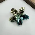 Iridescent plating plumeria hair clip with metallic gradient finish on gray surface - Green and Yellow Gradient