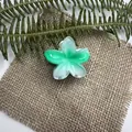 Molla per capelli a forma di fiore sfumato verde e bianco su sfondo di lino naturale - Leva Verde
