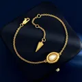 Elegant gold O-chain bracelet featuring a white oval shell inlay and cone charm - Gold White Shell Bracelet