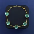 Macro detail of gold-plated bracelet featuring five cushion-cut light blue gemstones - Gold + Sea Blue