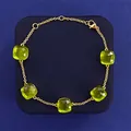 Gold bracelet with five square green emeralds on blue jewelry box, minimalist design - Gold Tone + Grass Green