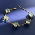 Close-up of five faceted green crystals on a gold chain bracelet with lobster clasp - Gold (Green + Clear)