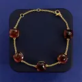 Minimalist gold bracelet featuring five square red gemstones with lobster clasp closure - Gold + Purple