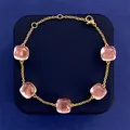 Gold chain bracelet featuring five square pink crystal stones on a navy display box - Gold Tone + Clear Pink