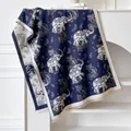 Close-up of deep blue cashmere scarf featuring paisley elephant patterns and fringed edges - Blue