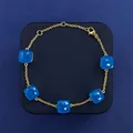 Elegant gold chain bracelet featuring five square blue gemstones on a jewelry box - Gold Tone + Sea Blue Jade
