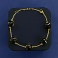 Gold chain bracelet featuring five square faceted black gemstones with adjustable lobster clasp - Gold + Black