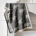 Detailed view of elephant jacquard scarf with tassels on a minimalist mantle - Gray