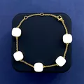 Elegant gold chain bracelet with five white square gemstone charms on dark display - Gold and Milky White